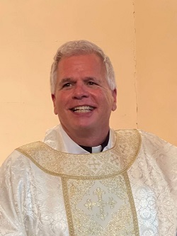 Portrait of Father Michael Ellis in white clergy vestments 