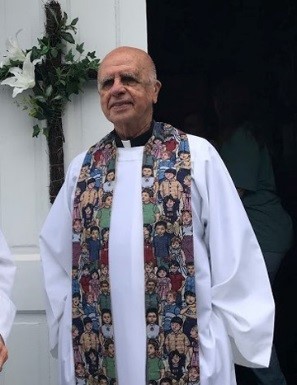 portrait of Fr. Desantis dressed in white alb and multicolored stole